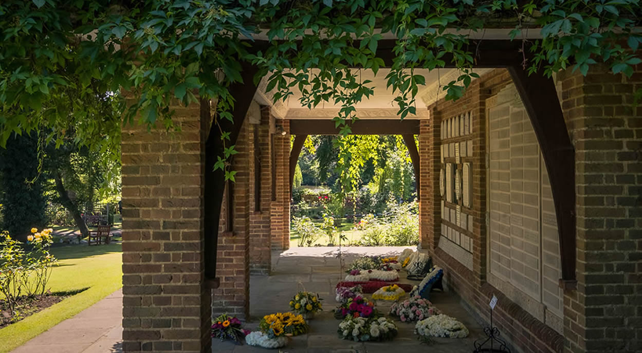 Brick archway with memorial plaques and flowers